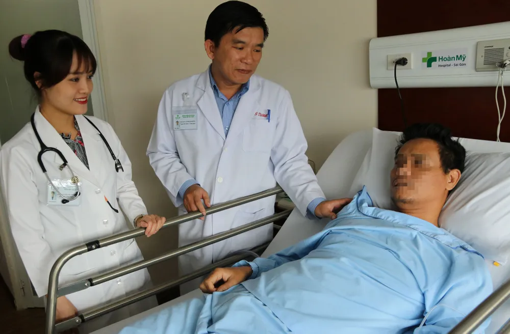 ​  Bác sĩ Cao Minh Thông thăm khám bệnh nhân sau phẫu thuật.