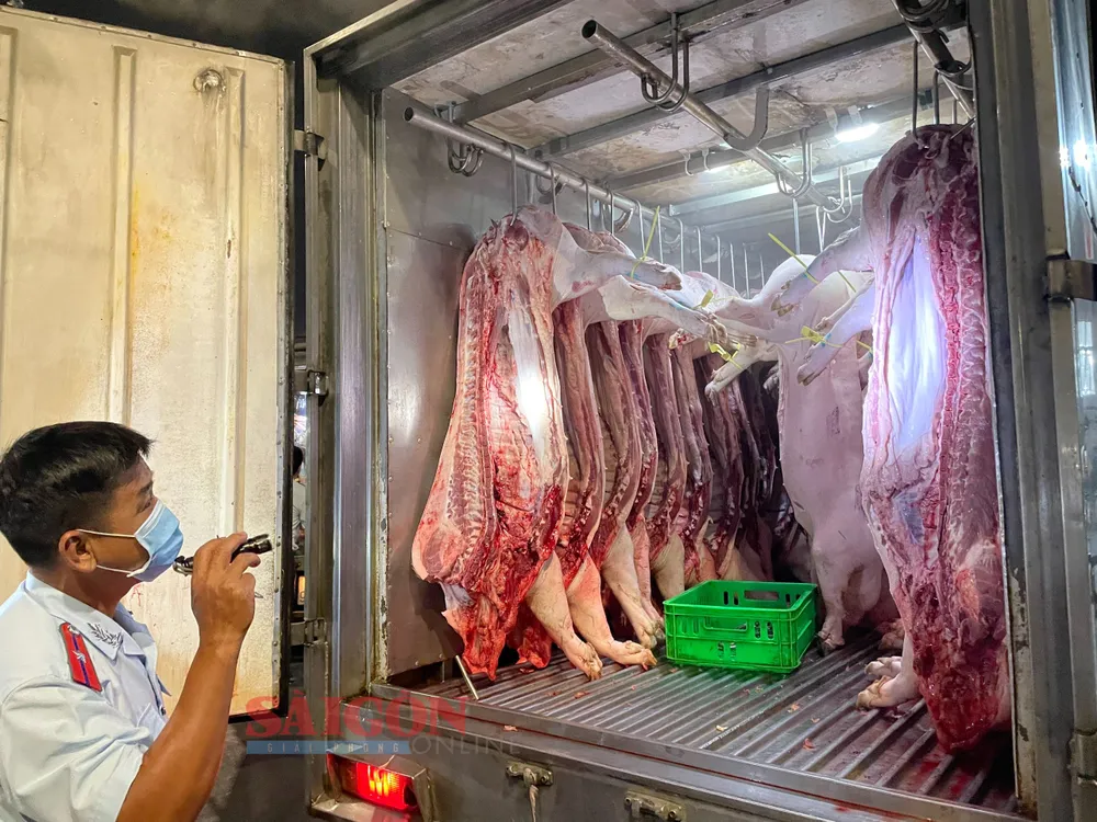 Nhân viên Đội Quản lý ATTP số 9 kiểm tra nguồn gốc thịt heo