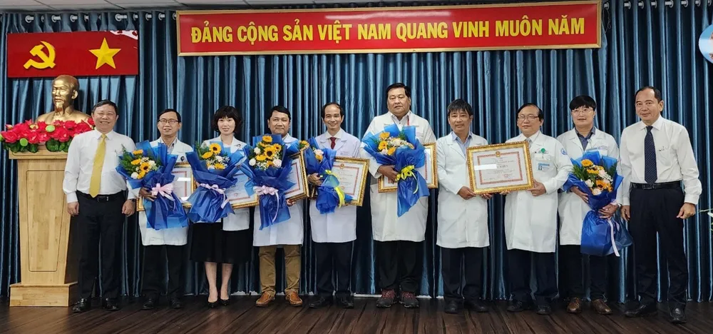 Phó Chủ tịch UBND TPHCM Dương Anh Đức (bìa trái) trao tặng bằng khen cho ekip thực hiện