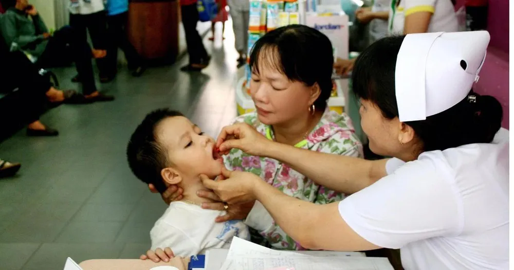 Nhân viên y tế cho trẻ uống bổ sung Vitamin A