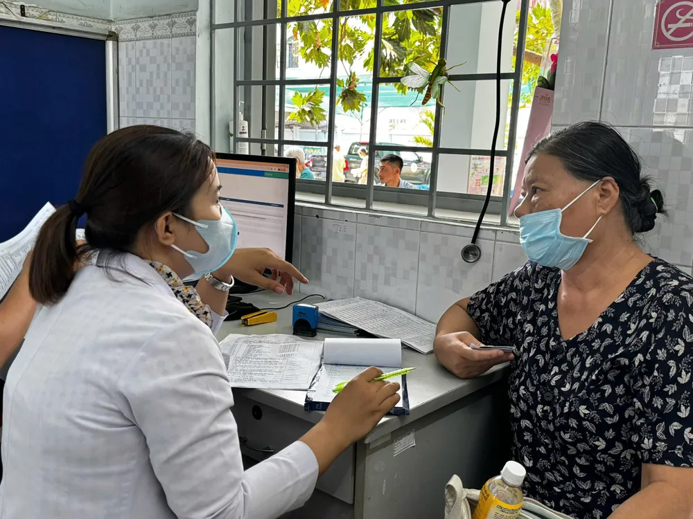 Nhân viên Trạm y tế phường Phước Long (TPHCM) đang thăm khám cho người bệnh