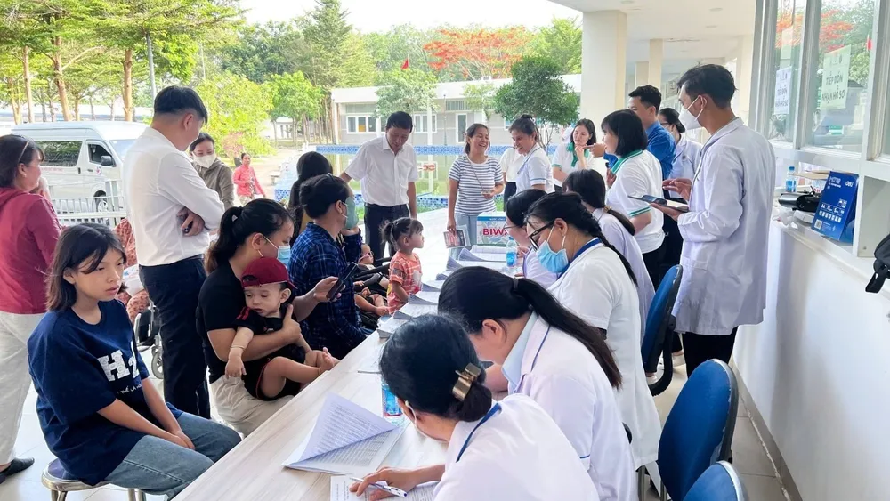Nhân viên y tế tiếp đón, hướng dẫn và hỗ trợ làm thủ tục khám cho trẻ