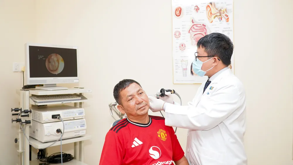 ThS-BS Nguyễn Lê Nhân Văn, bác sĩ Trung tâm Tai Mũi Họng Chuyên sâu và Phẫu thuật Đầu Cổ, nội soi tai cho người bệnh trong lần tái khám.