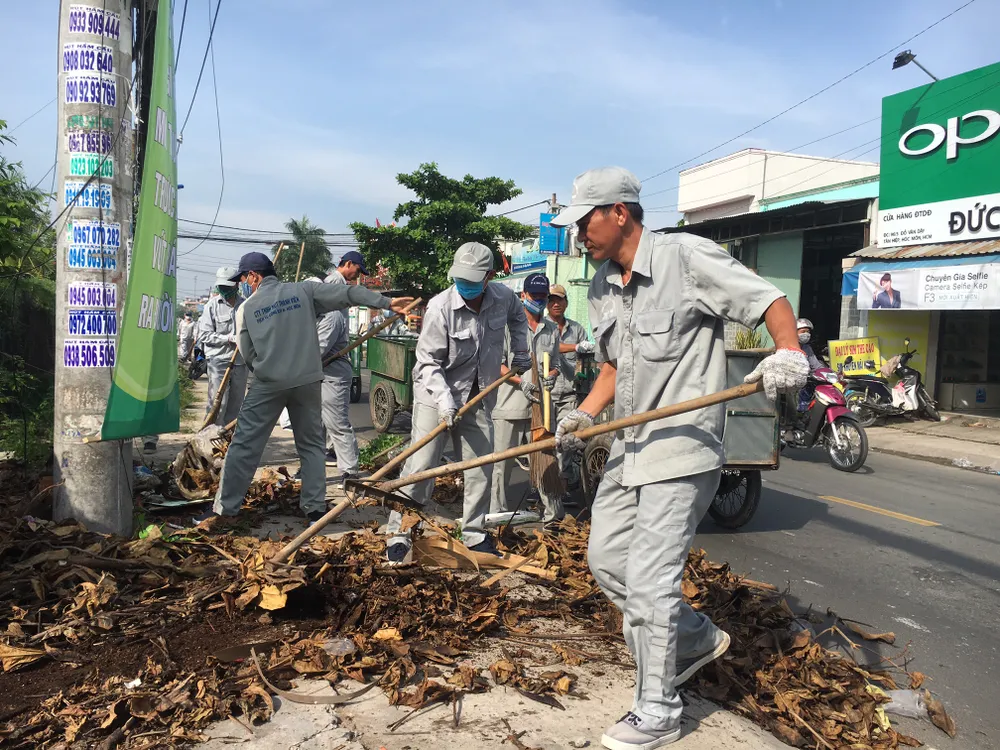 Người dân quét dọn sau khi tham dự hưởng ứng Tuần lễ Quốc gia nước sạch và vệ sinh môi trường
