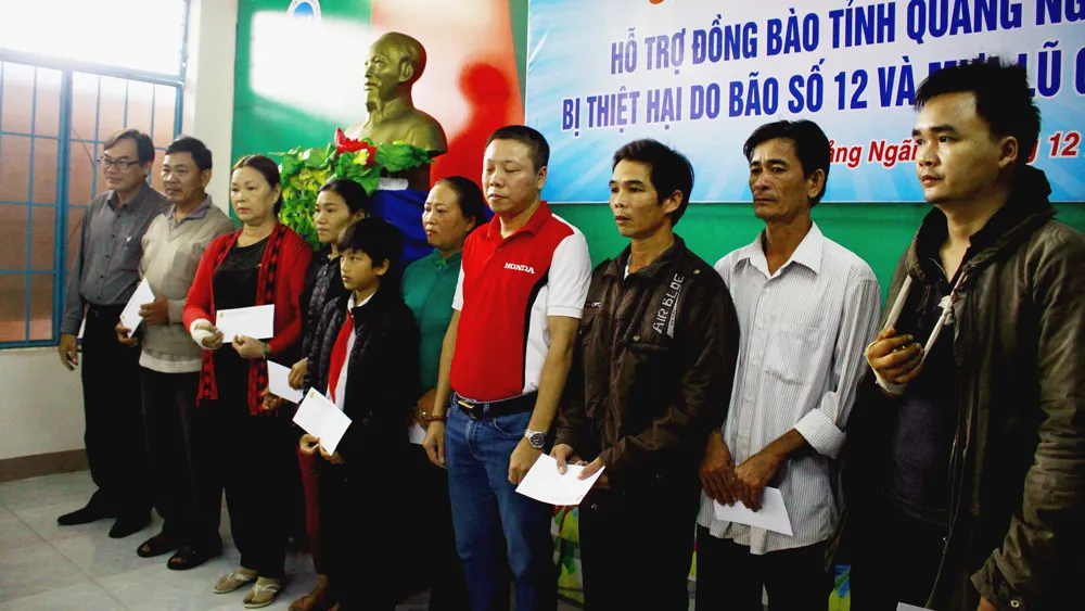 Trao quà hỗ trợ cho các gia đình có người bị thương, chết do mưa lũ. Ảnh: NGUYỄN TRANG