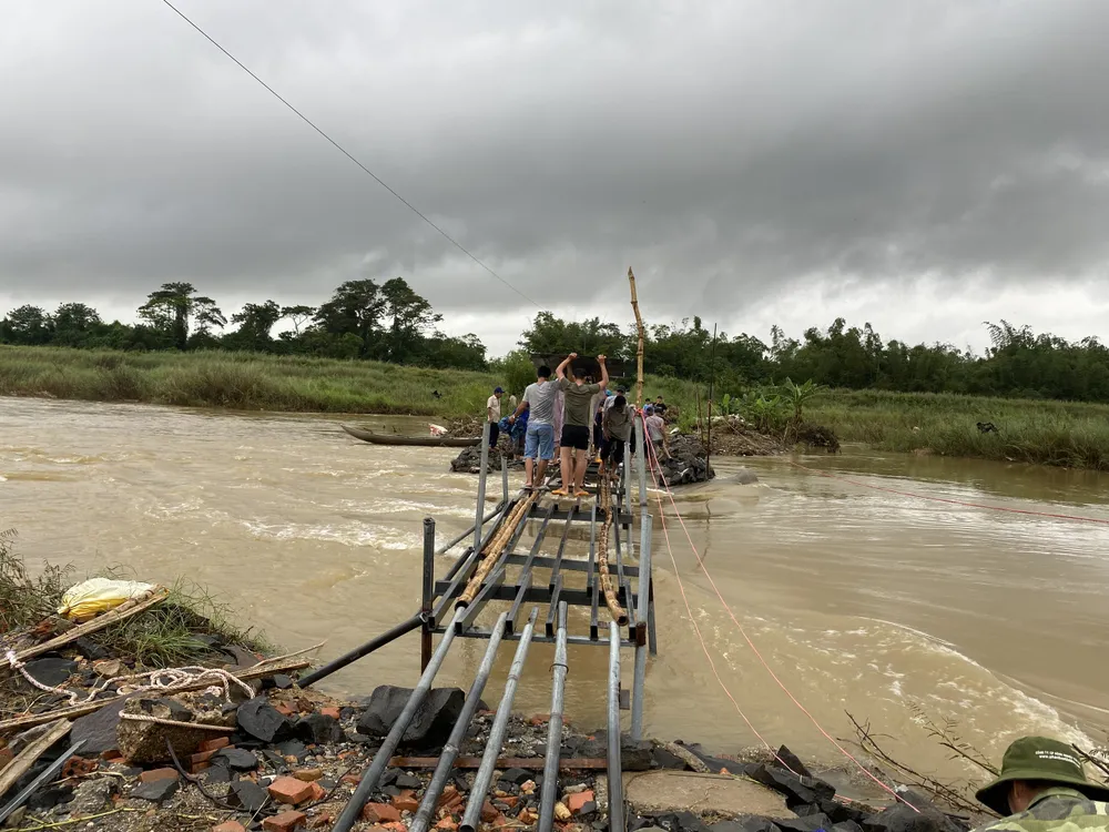 Người dân làm cầu sắt bắc qua sông Trà Khúc vào chiều ngày 4-12