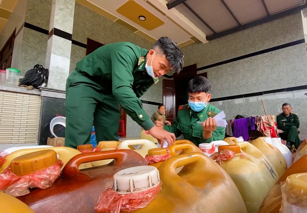 Lực lượng chức năng kiểm đếm số lượng can nhựa và dầu DO trong khu vực phát hiện.