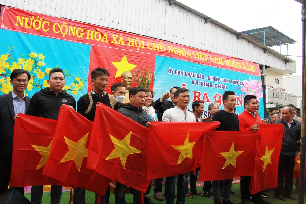 Các ngư dân nhận lá cờ Tổ quốc trong lễ ra quân. Ảnh: NGUYỄN TRANG