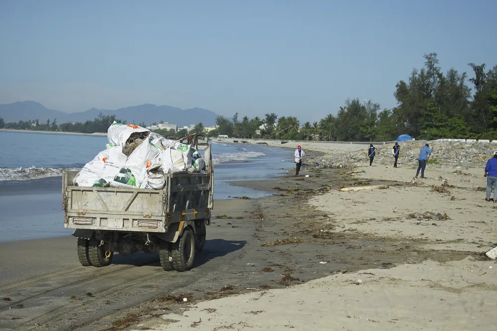 Xe tải chở rác dọc bãi biển để đưa ra cho xe của công ty môi trường