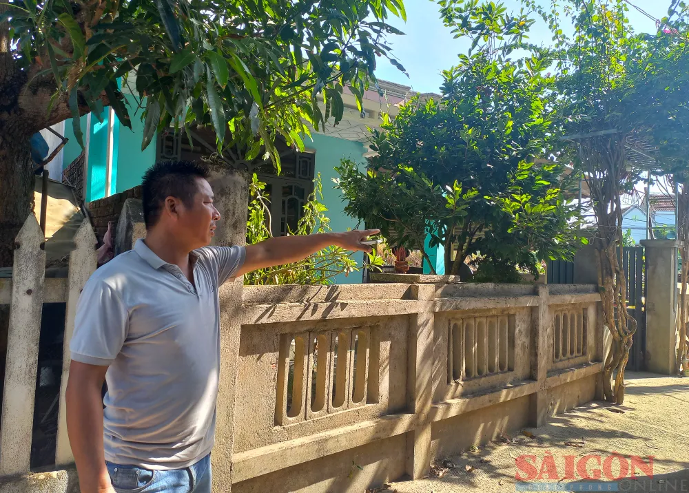 Anh Phan Đình Phụng đứng trước dãy nhà người dân xóm Khê Nam chưa được cấp sổ đỏ. Ảnh: NGUYỄN TRANG