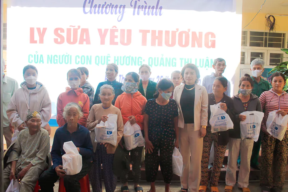 Người dân nhận những ly sữa yêu thương từ chị Luận. Ảnh: NGUYỄN TRANG