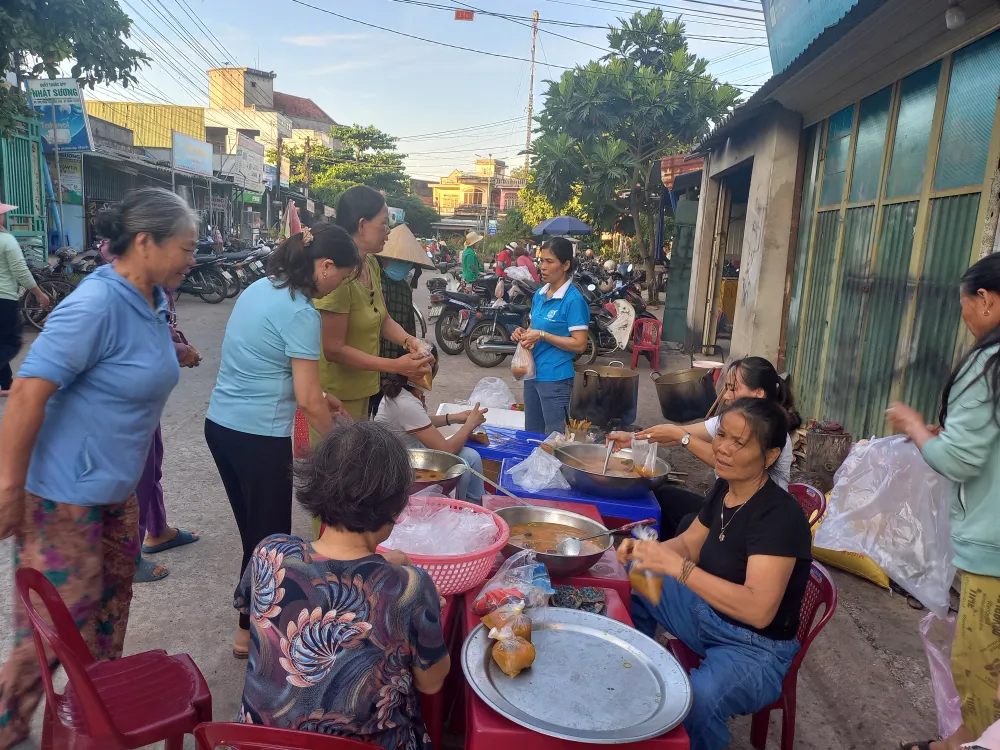 Phụ nữ xã Bình Phú nấu cháo miễn phí từ sự hỗ trợ chị Luận. Ảnh: NGUYỄN TRANG
