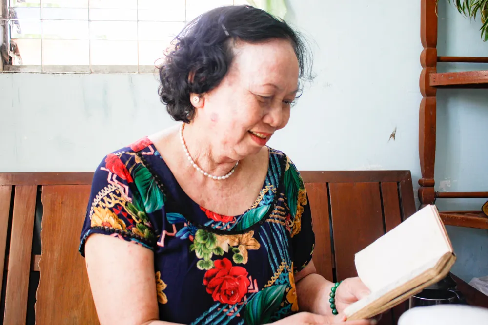 Bà Hiền cầm cuốn nhật ký đọc lại những dòng đã ghi. Ảnh: NGUYỄN TRANG
