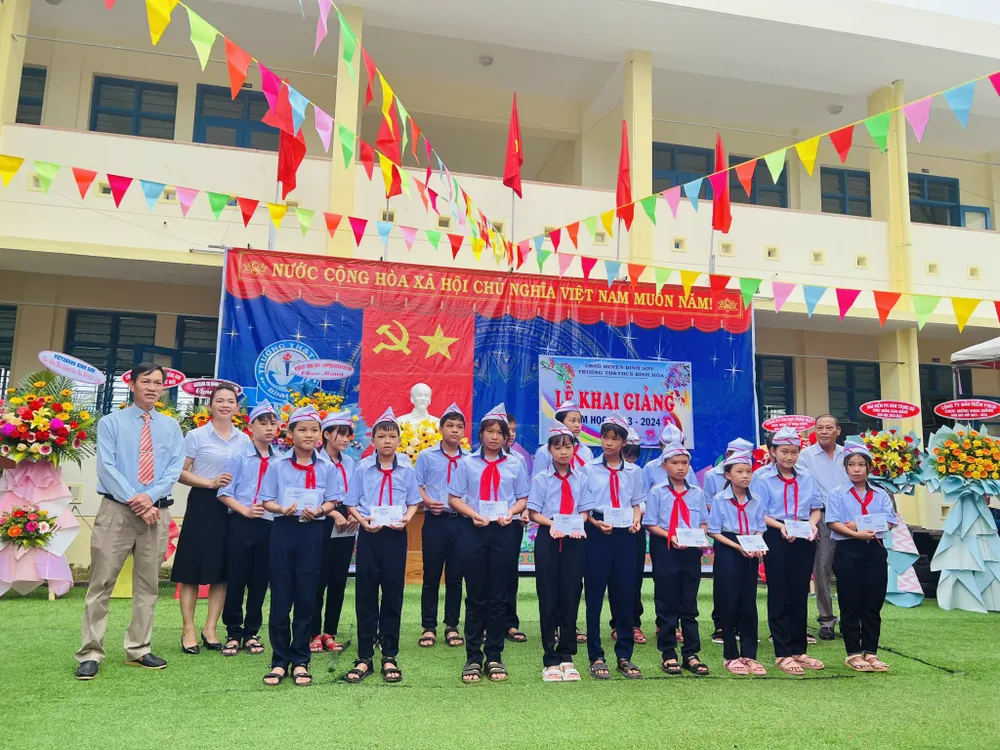 Các em học sinh nghèo vượt khó của Trường Tiểu học và THCS Bình Hòa nhận học bổng. Ảnh: NGUYỄN TRANG