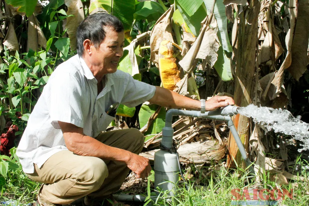 Ông Bảnh bên giếng khoan do ông bỏ tiền túi đóng cho dân làng để có nước sạch dùng. Ảnh: NGUYỄN TRANG Ông Bảnh bên giếng khoan do ông bỏ tiền túi đóng cho dân làng để có nước sạch dùng. Ảnh: NGUYỄN TRANG
