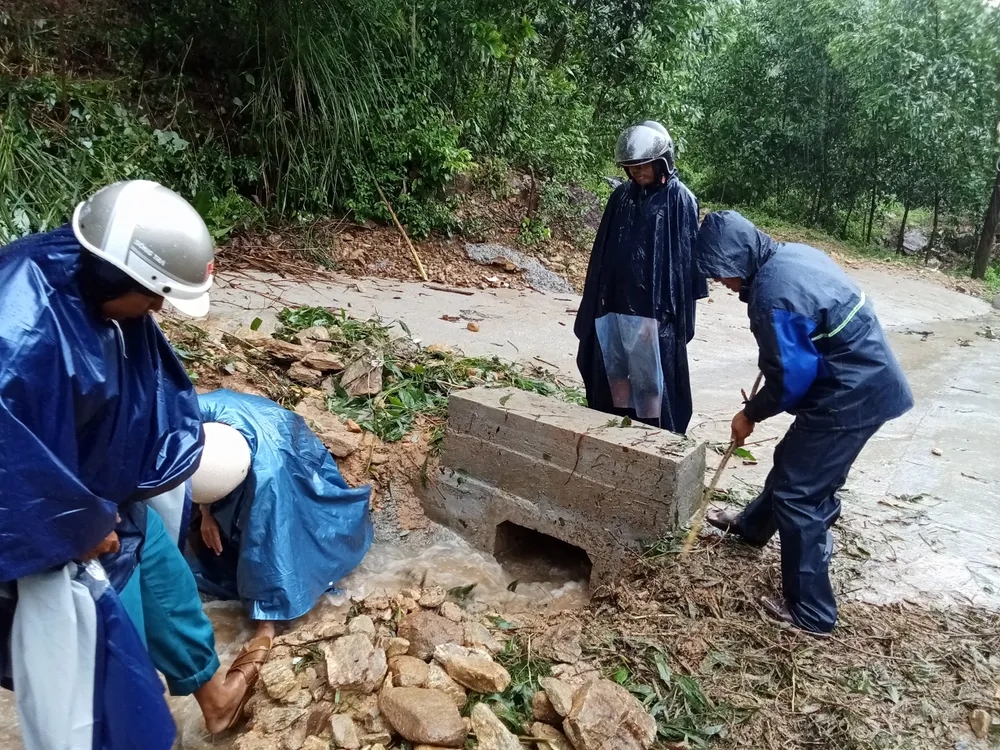 Cán bộ địa phương đang thực hiện thông cống thoát nước vì bị đất đá vùi lấp