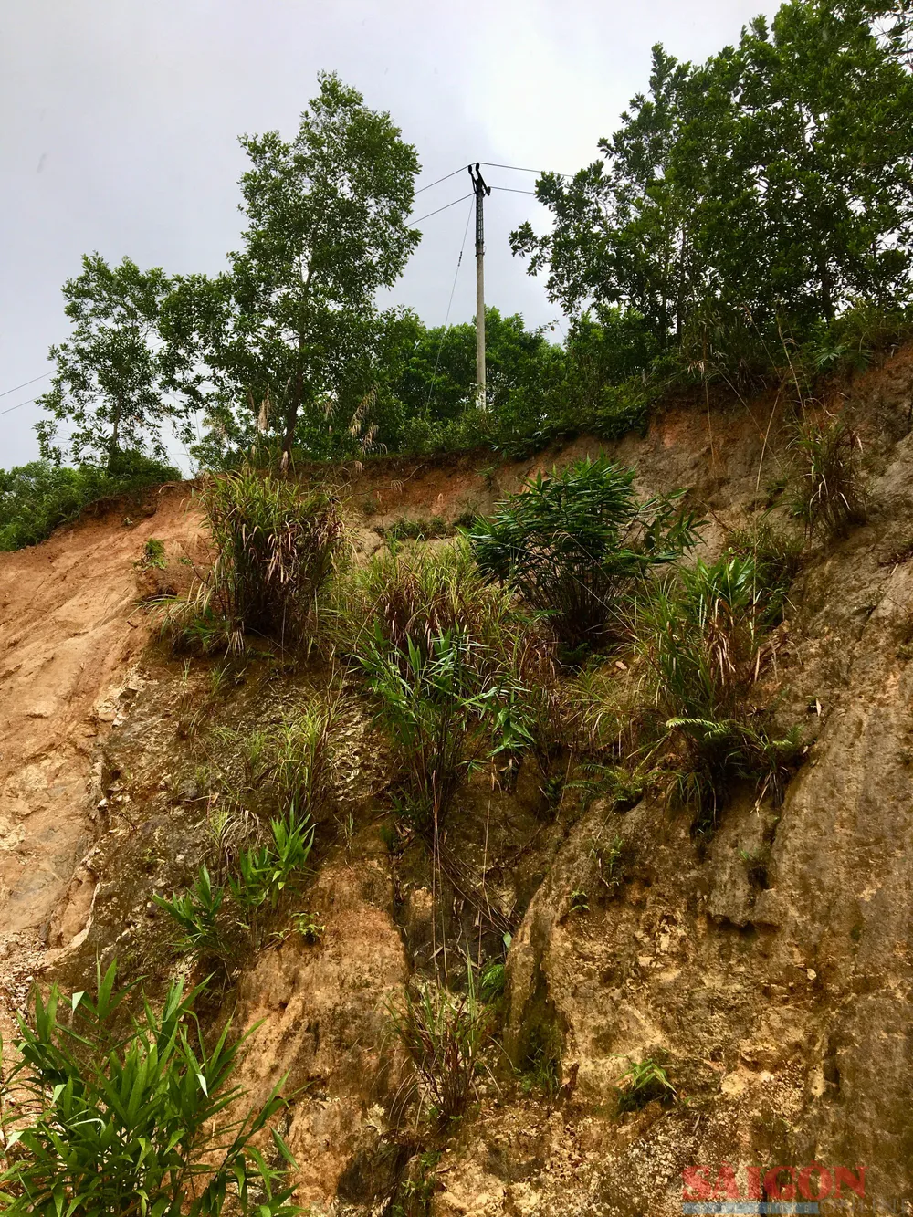 Trụ điện trên sườn núi này chỉ còn cách mép chưa đầy 1m, nguy cơ sạt lở lớn. Ảnh: TIẾN DŨNG