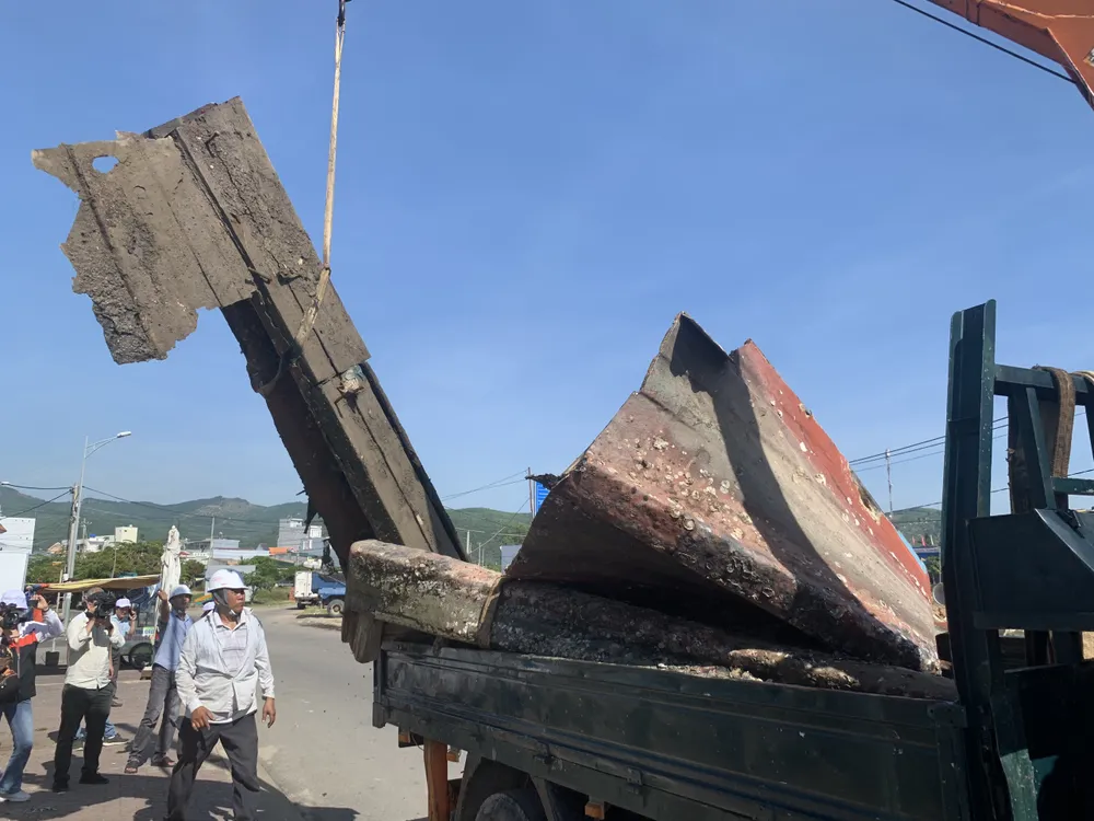 Xác tàu được cưa xẻ để đưa lên xe đến nơi xử lý