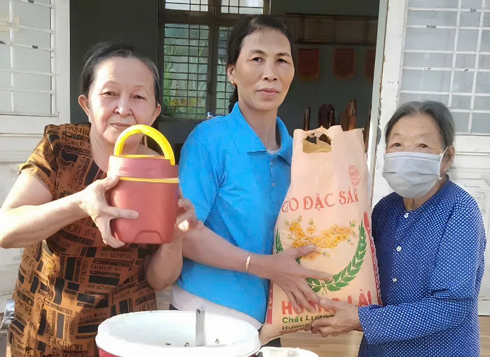 Bà Tình quyên góp gạo tặng cho các cụ già có hoàn cảnh khó khăn trong thôn xóm và phát cháo. Ảnh: NGUYỄN TRANG