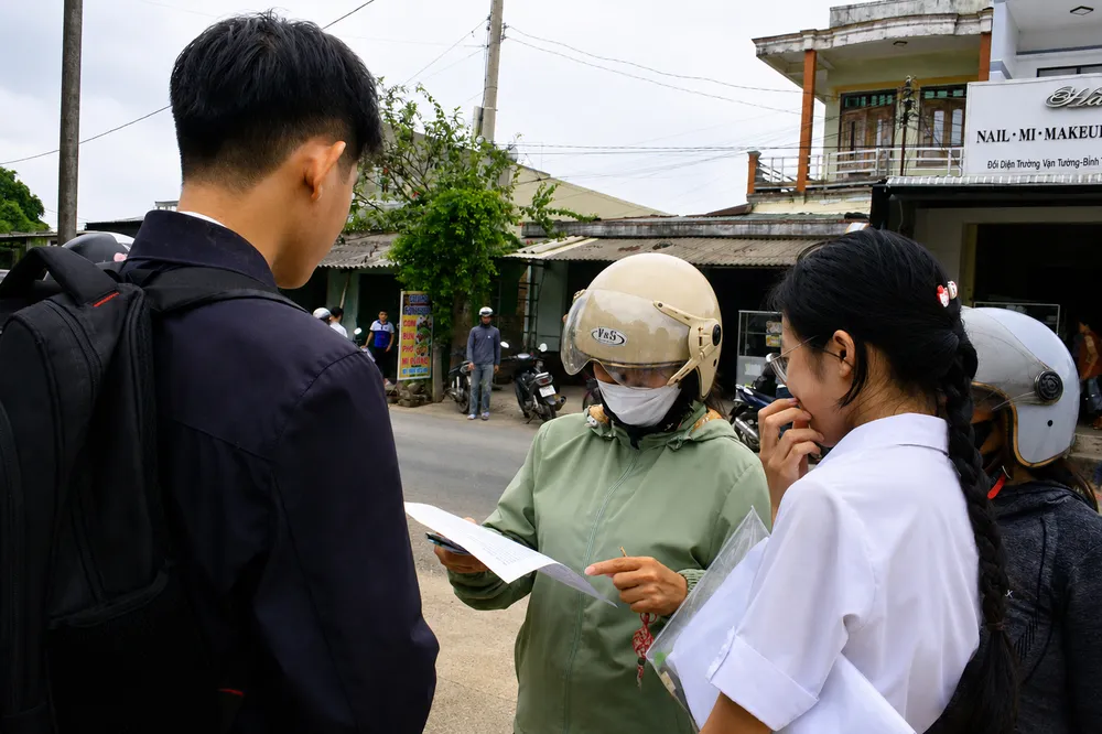 Phụ huynh xem đề thi Ngữ văn và thảo luận cùng con sau môn thi. Ảnh: NGUYỄN TRANG
