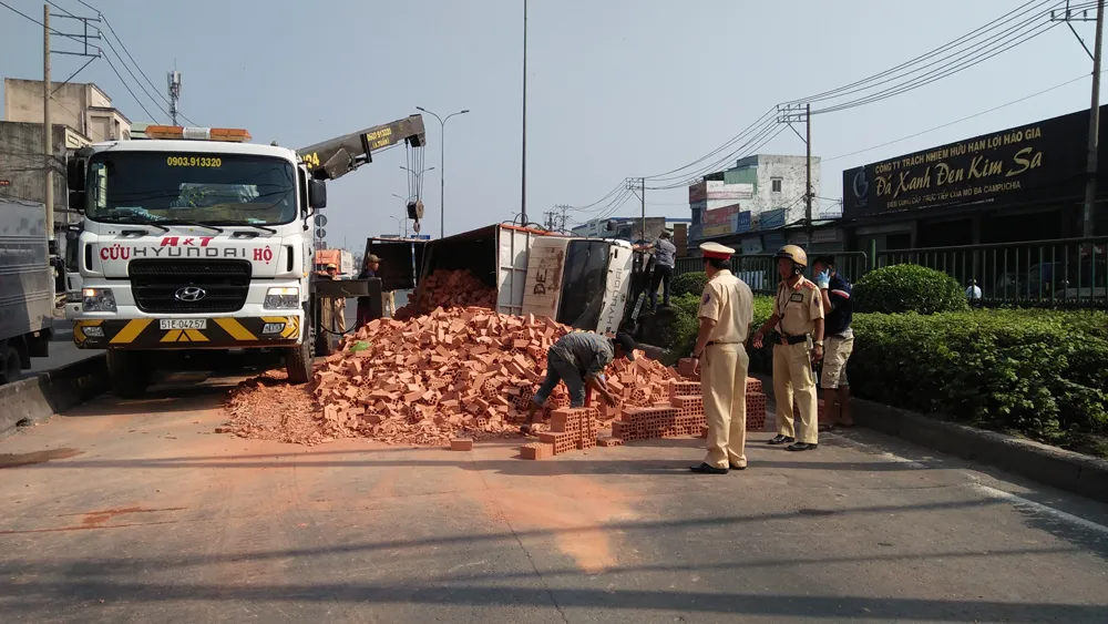 Xe tải chở gạch lật ngang, tài xế cùng phụ xe mắc kẹt kêu cứu trong cabin ảnh 2