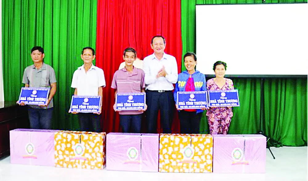  Ông Lưu Hoàng Tân - Chủ tịch, Giám đốc Công ty TNHH MTV Xổ số kiến thiết Đồng Tháp trao bảng tượng trưng  và quà cho 5 hộ nghèo