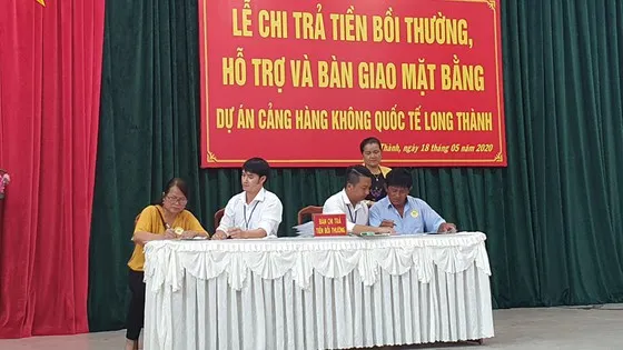 Người dân nhận tiền đền bù đợt tháng 5-2020. Ảnh: VŨ PHONG