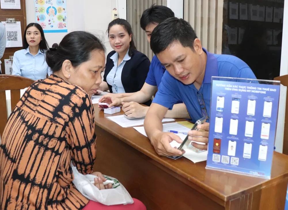 Cán bộ Trung tâm Phục vụ hành chính công phường Xóm Chiếu hỗ trợ người dân thực hiện thủ tục hành chính. Ảnh: THÁI PHƯƠNG