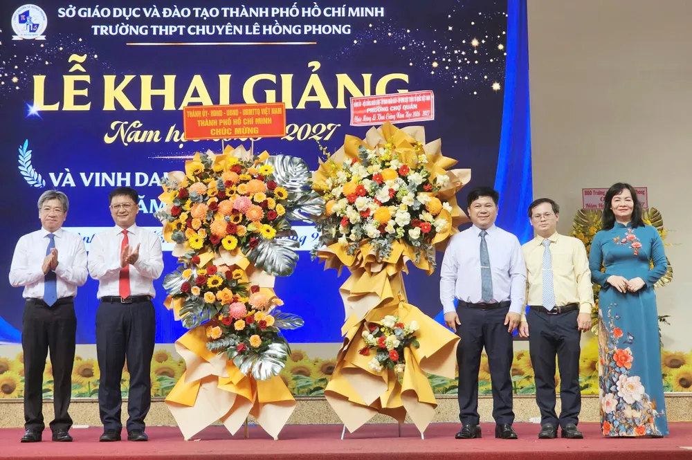 Phó Chủ tịch UBND TPHCM Nguyễn Mạnh Cường, và Chủ tịch UBND phường Chợ Quán Nguyễn Võ Xuân Kỳ tặng hoa chúc mừng tập thể sư phạm Trường THPT chuyên Lê Hồng Phong, TPHCM.