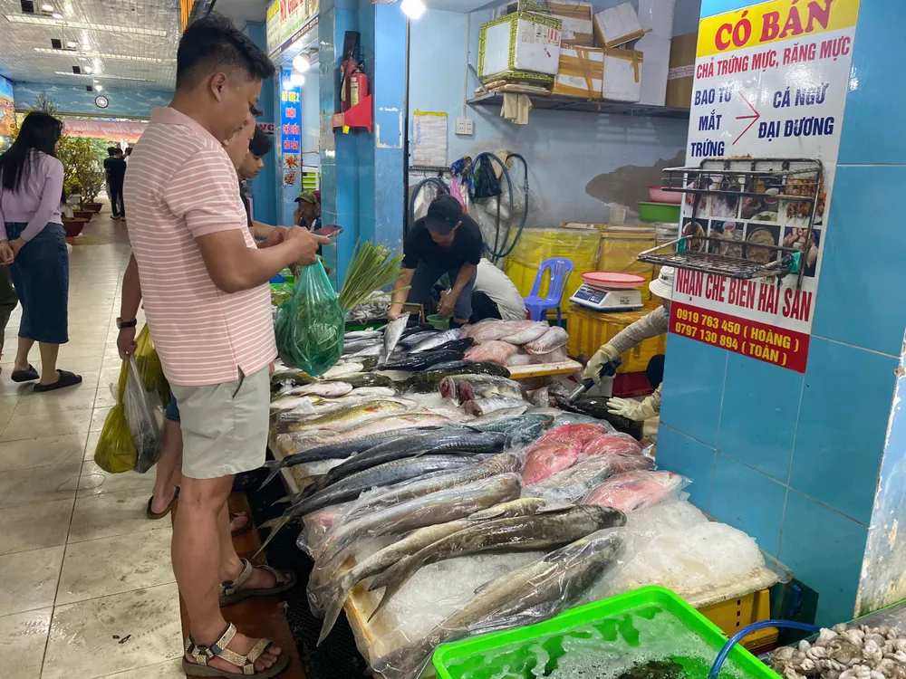 Du khách lựa mua cá tươi