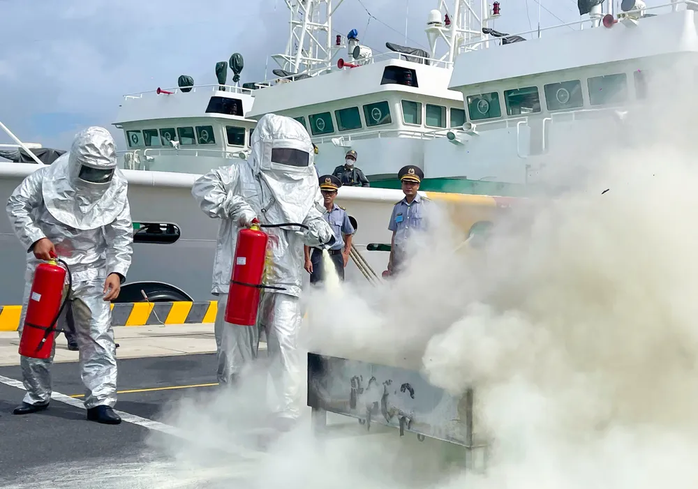 Cán bộ, nhân viên Chi đội Kiểm ngư số 2 tham gia chữa cháy bằng bình cứu hỏa. Ảnh: MẠNH THẮNG