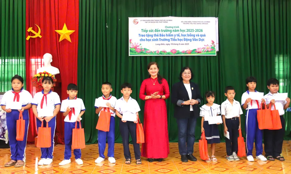 Nhà báo Bùi Hương, Phó Tổng Biên tập Phụ trách Tạp chí Khoa học phổ thông và lãnh đạo nhà trường trao thẻ bảo hiểm cho học sinh