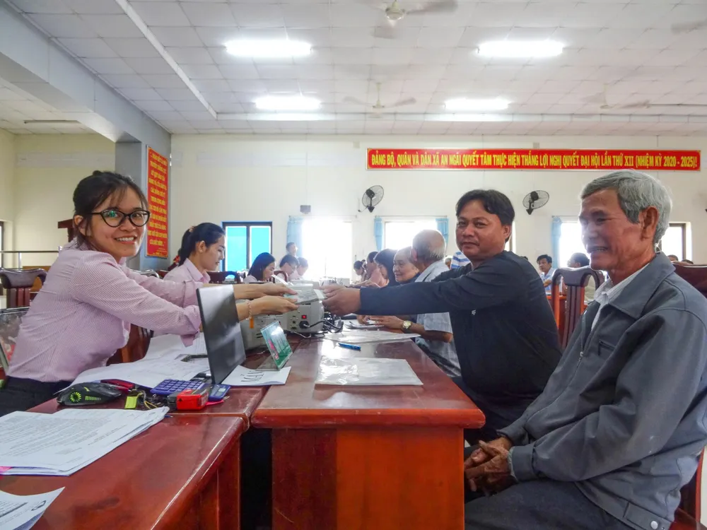 Nhân viên Phòng Giao dịch NHCSXH Bà Rịa - Vũng Tàu giải ngân vốn tín dụng tại xã Long Điền