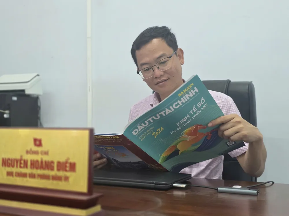 Cán bộ xã Kro6ng Nô, tình Đắk Lắk đọc báo Xuân SGGP Đầu tư Tài chính.jpg