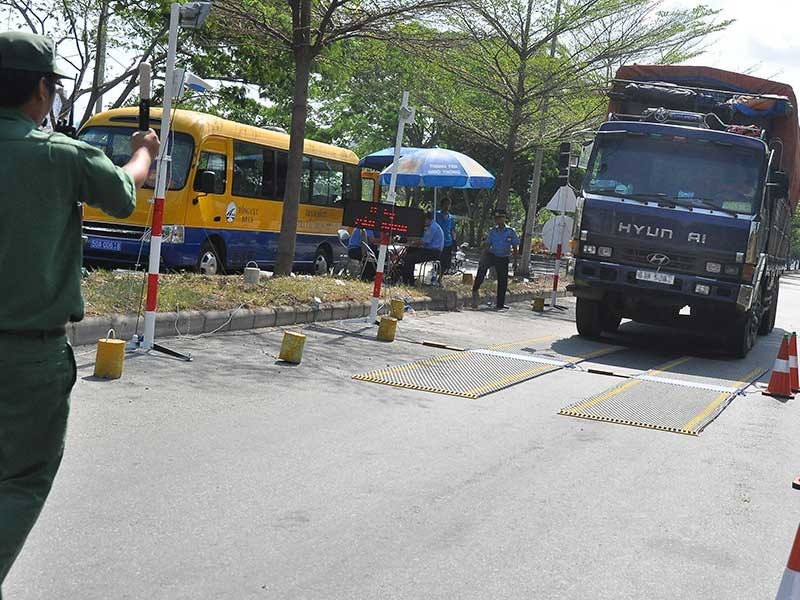 職責人員指引一輛有超載跡象的車輛進入秤車站。