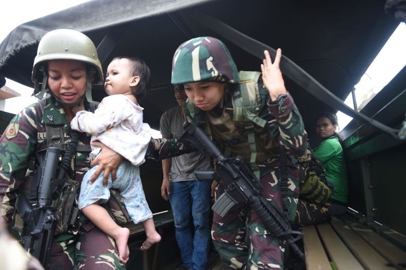 菲律賓馬拉維6月25日，一名軍人懷抱一名被解救的嬰兒。