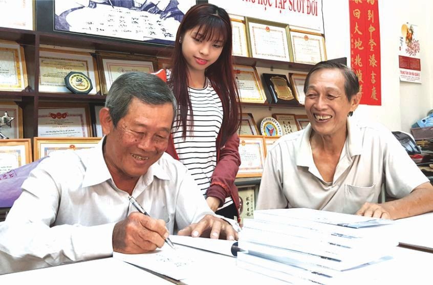 劉為安先生(左一)正在簽名贈書給文友。