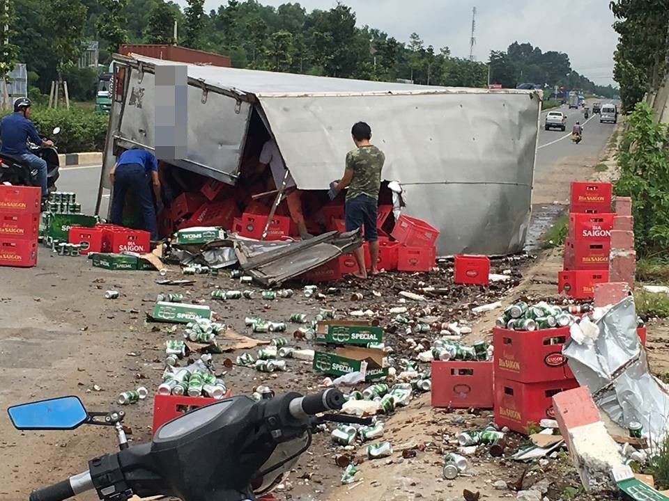 運載啤酒卡車失控側翻，導致上百箱啤酒跌落滿路，民眾幫助司機撿拾啤酒並清理現場，確保路人交通安全。（圖源：）