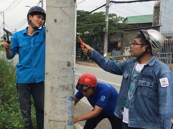 守德郡三富坊幹部和青年正在清理 乾淨貼在電線杆、牆壁上的廣告、傳單。