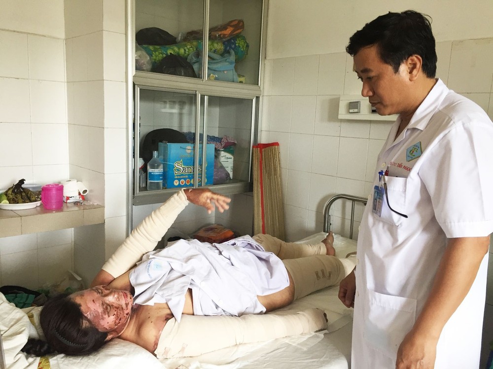 秦玉山醫生在問診灼傷者翁氏簪。（圖源：H.Hoa）