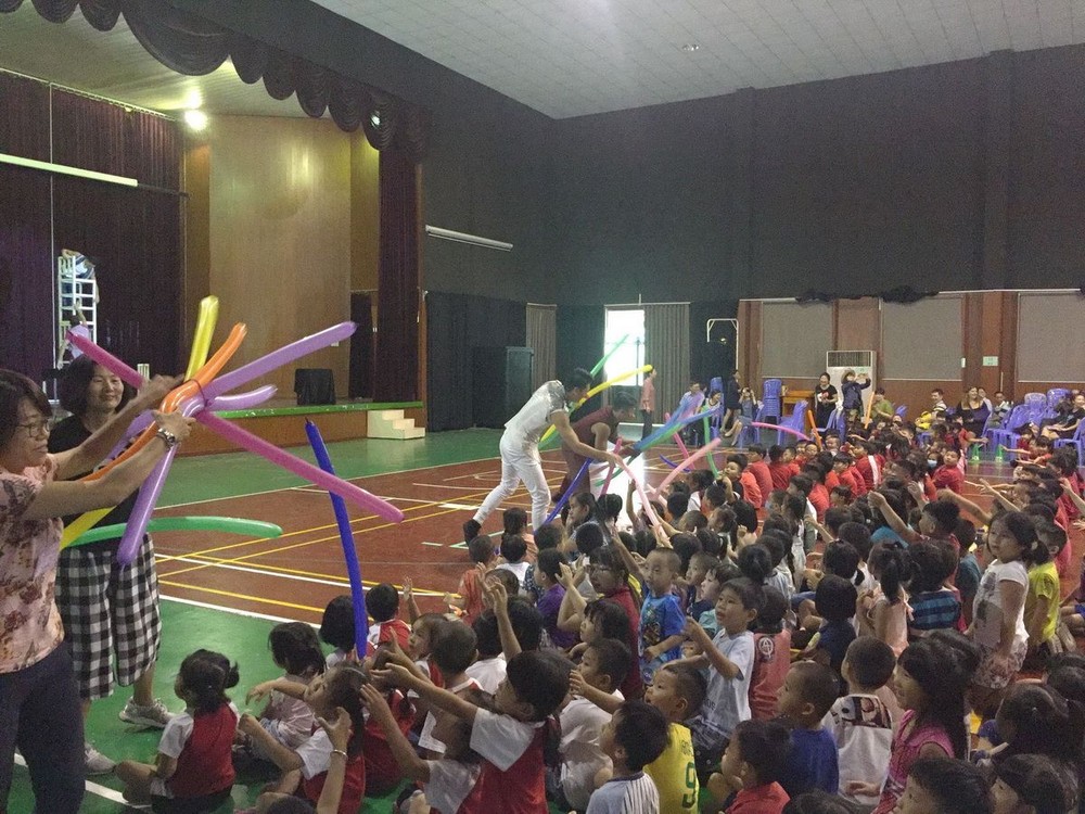 雜技演員送氣球給學生。