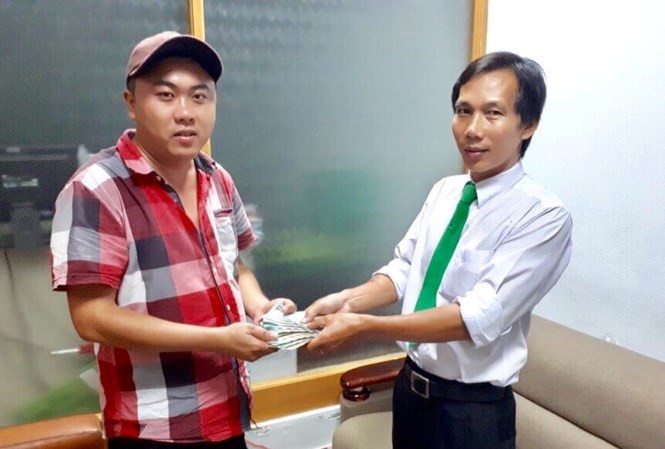 乘客蘇英文(左)從司機手上接回所遺忘的財物。（圖源：ML）