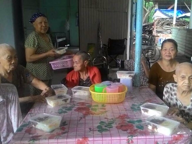 黎氏敬老師向老人們送上晚飯。