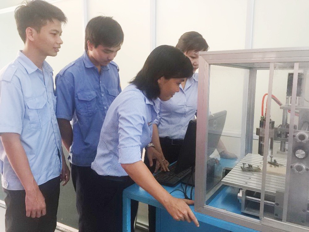 機械學科師生正實習操作金屬加工CNC工業銑床模型。