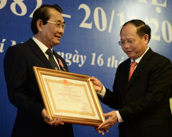 市委常務副書記畢成剛向市教育部 門工會主席阮友雄轉授國家主席的三等 勞動勳章。（圖源：自忠）