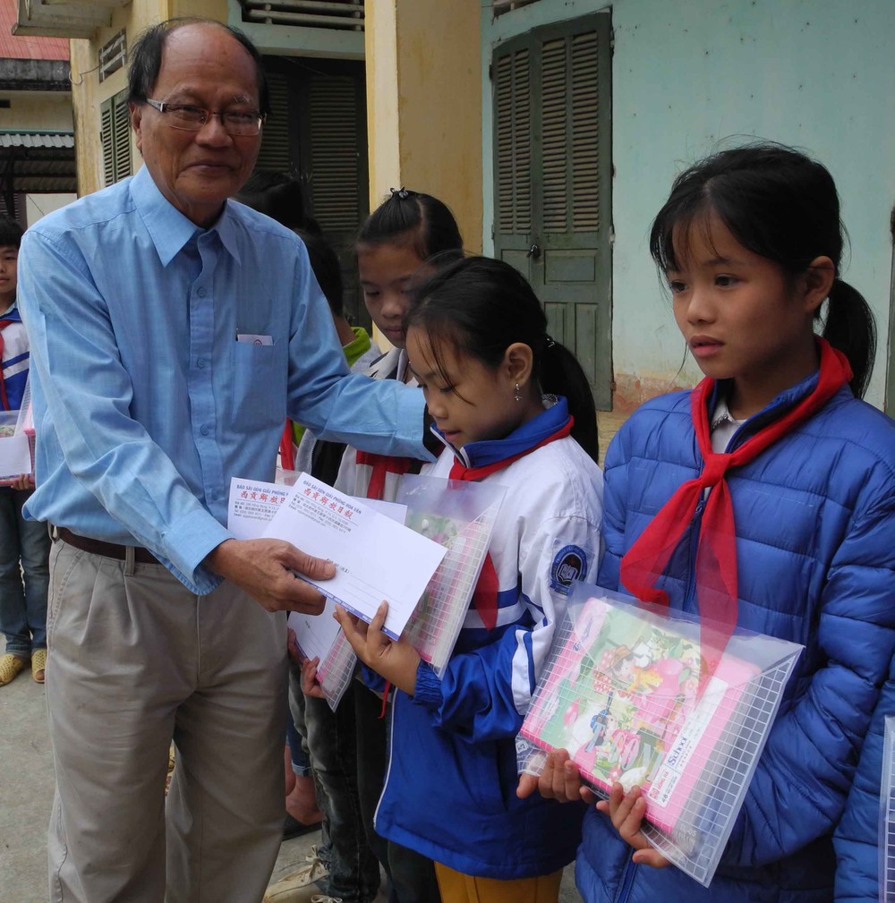 溫陵會館常值副理事長洪世真代表轉交本報贈送的禮物代金予貧困學生。