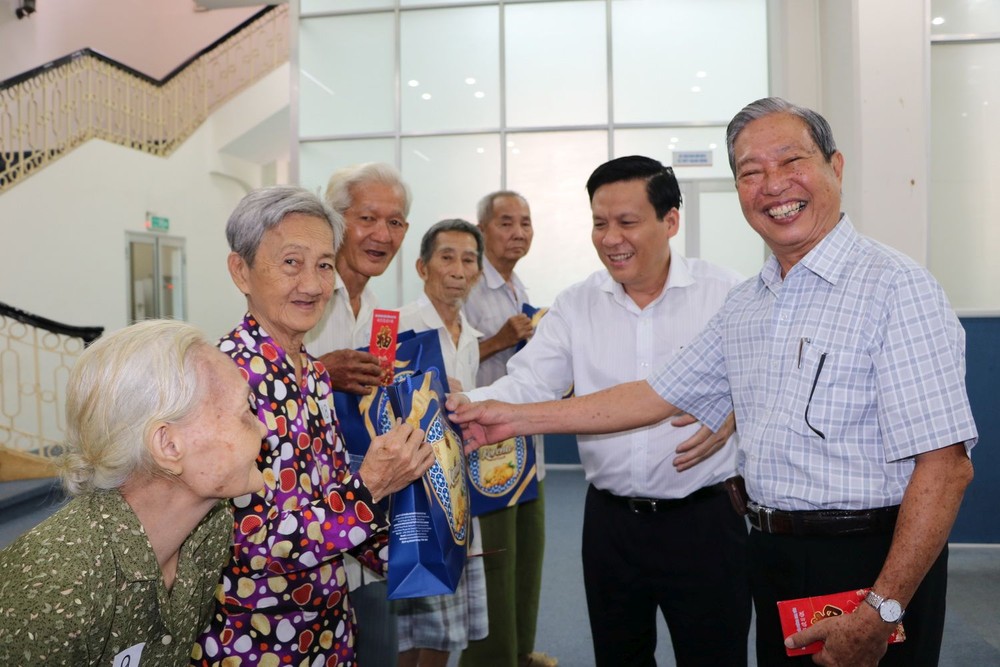 阮玉英主編(右二)和楊順龍先生(右一) 向貧病老人贈送禮物。