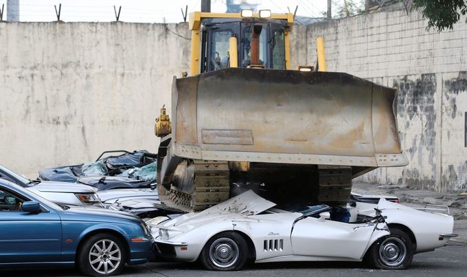 推土機輾碎二十輛走私名車。（圖源：路透社）