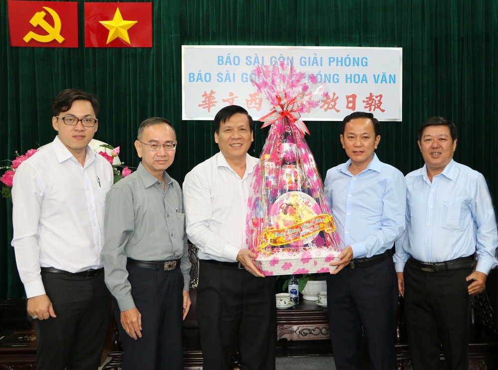 本報主編阮玉英(中)接受代表團的賀禮。