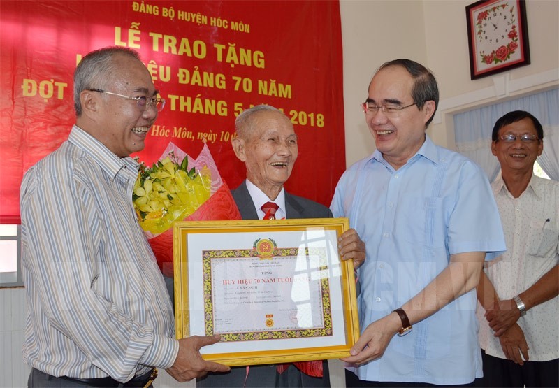 市委書記阮善仁頒授紀念章給黎文毅同志。